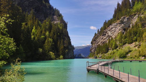 Panoramic view of swimming pool by lake against sky