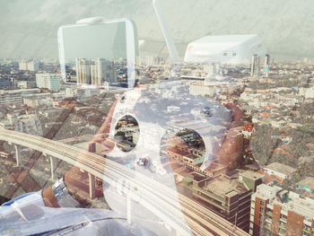 Double exposure of person with drone remote control and cityscape