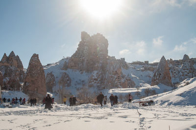 Panoramic view of people on snowcapped mountain against sky