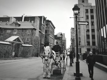 People walking on street amidst buildings in city