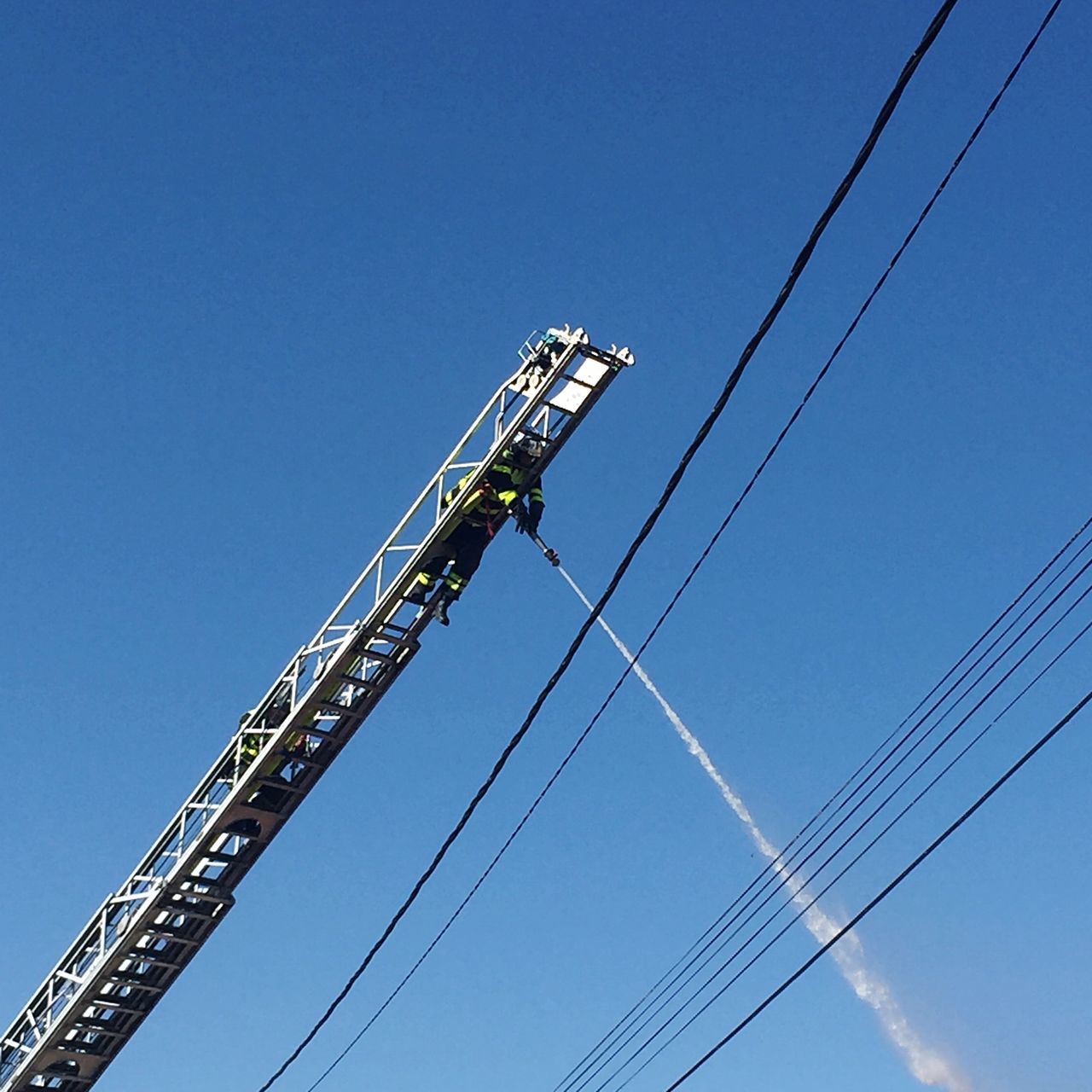 sky, low angle view, blue, nature, clear sky, cable, day, technology, connection, electricity, metal, outdoors, no people, fuel and power generation, machinery, industry, tall - high, copy space, power line, power supply