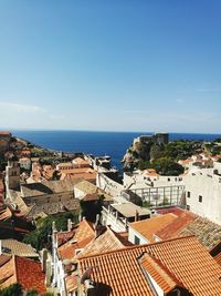 High angle view of townscape by sea against sky