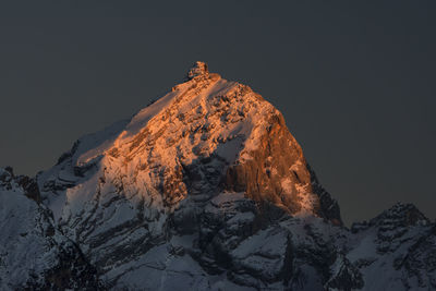 Low angle view of snowcapped mountain against sky at night