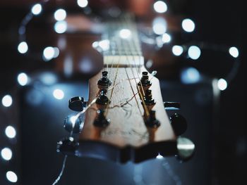 Close-up of guitar with illuminated string lights