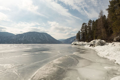 View of beautiful drawings on ice from cracks on the surface of lake teletskoye in winter, russia