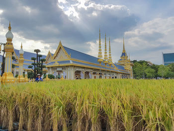 Exterior of temple on field against sky