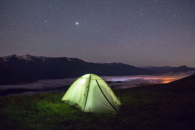 Tent on field against sky at night