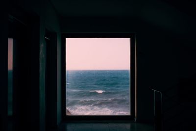 Close-up of sea against clear sky seen through window