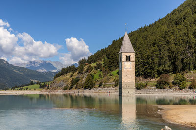 Scenic view of lake by building against sky