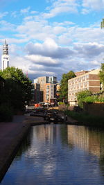 River amidst buildings in city against sky