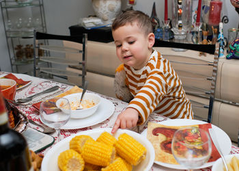 Curious little boy sitting at thanksgiving table