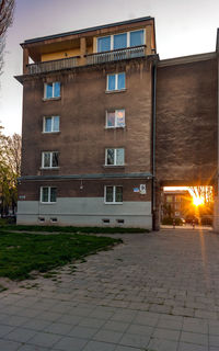 Street by building against sky at dusk
