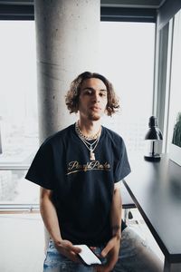 Portrait of young man looking down while standing on table