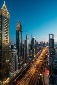 Buildings in city against clear blue sky