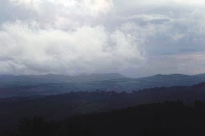 Scenic view of mountains against cloudy sky