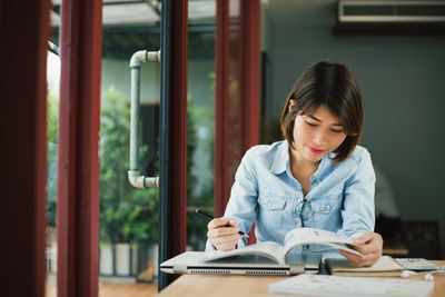 Young woman reading book at home