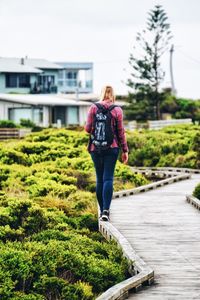 Rear view of woman standing against plants