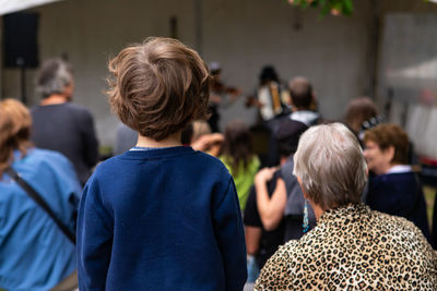 Rear view of people standing outdoors