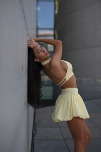 Rear view of woman standing against wall