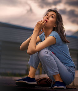 Full length of woman sitting outdoors