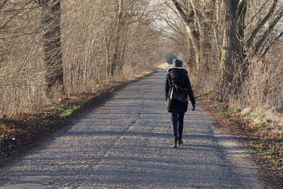 Rear view of woman walking on footpath