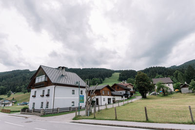 Houses by buildings against sky