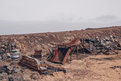 Old abandoned building on field against sky