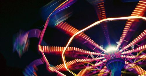 Low angle view of illuminated ferris wheel against sky at night