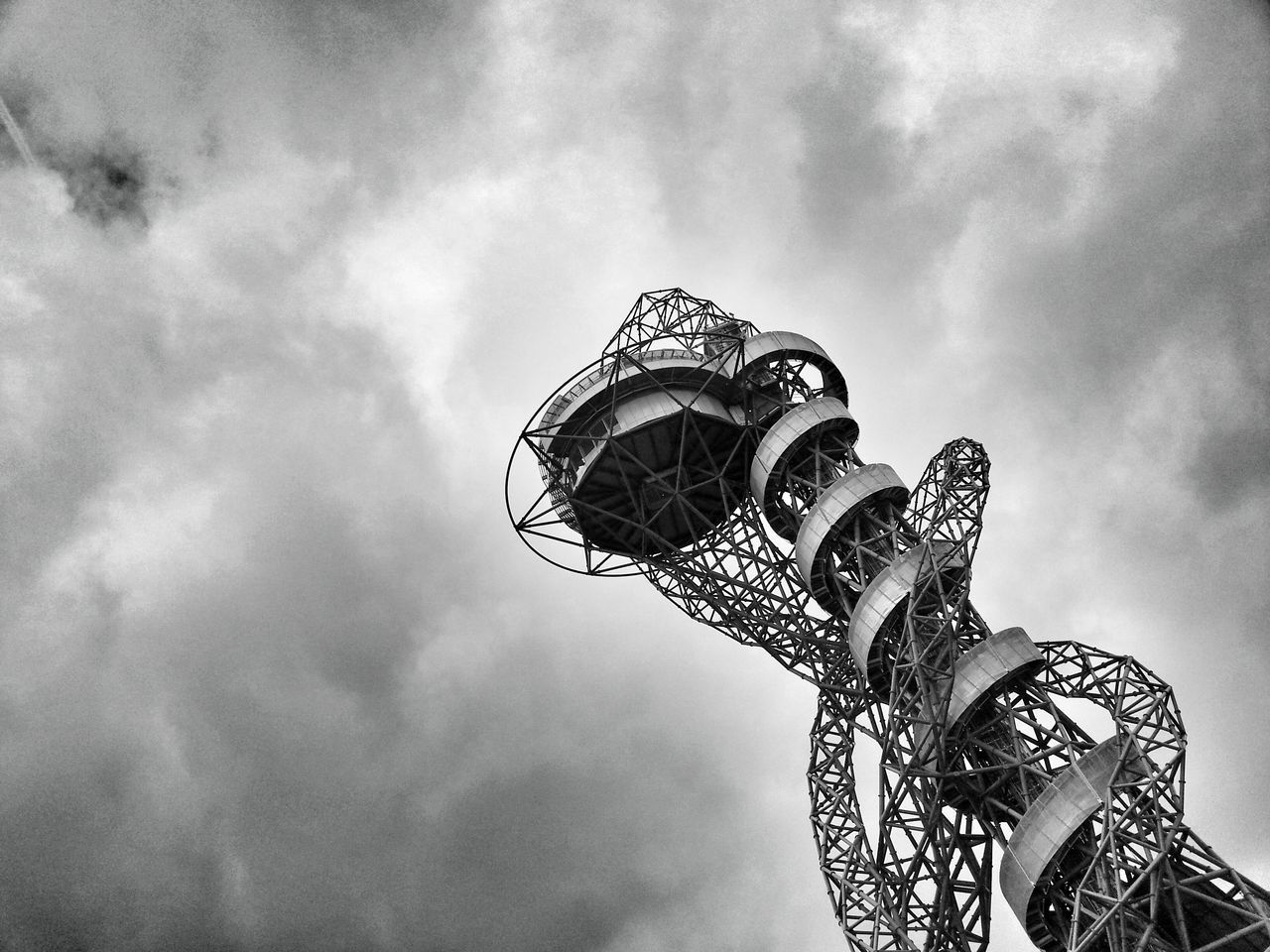 low angle view, sky, cloud - sky, cloudy, built structure, architecture, cloud, amusement park, metal, ferris wheel, arts culture and entertainment, amusement park ride, tall - high, metallic, overcast, day, no people, outdoors, tower, high section