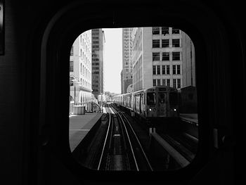 Train at railroad station in city against clear sky