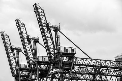 Low angle view of cranes against sky