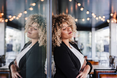 Portrait of relaxed business woman with eyes closed in cafe leaning on glass. business concept