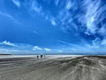 People at beach against sky