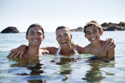Mother with sons bathing in sea
