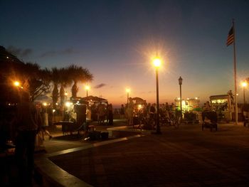 Illuminated street light against sky at night