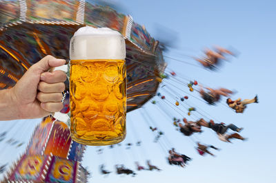 Close-up of hand holding beer glass