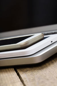 Close-up of smart phone and laptop with coffee cup on table