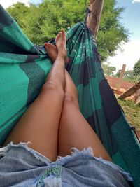 Low section of woman relaxing on hammock