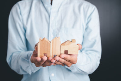 Close-up of man holding umbrella against white background