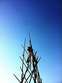 Low angle view of windmill against blue sky