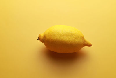 Close-up of lemon slice over yellow background