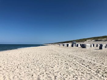 Scenic view of beach against clear blue sky