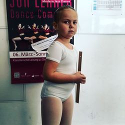 Portrait of girl standing against wall