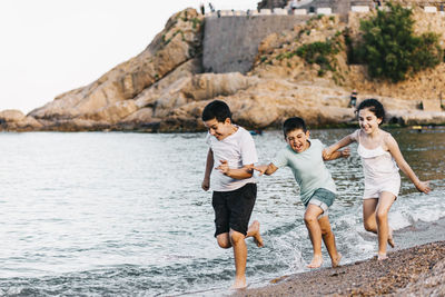 Full length of friends enjoying at beach