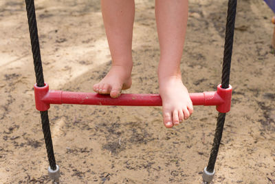 Low section of girl on swing in playground