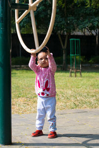 Full length of girl standing by exercise equipment at park