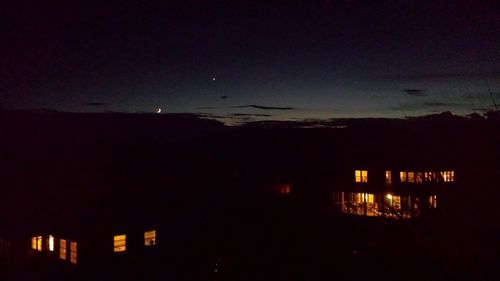 Illuminated buildings against sky at night