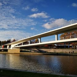 Bridge over river against sky in city