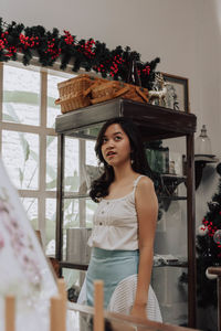 Portrait of smiling young woman standing at home