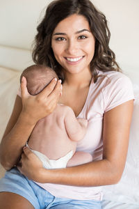 Portrait of mother with son sitting on sofa at home